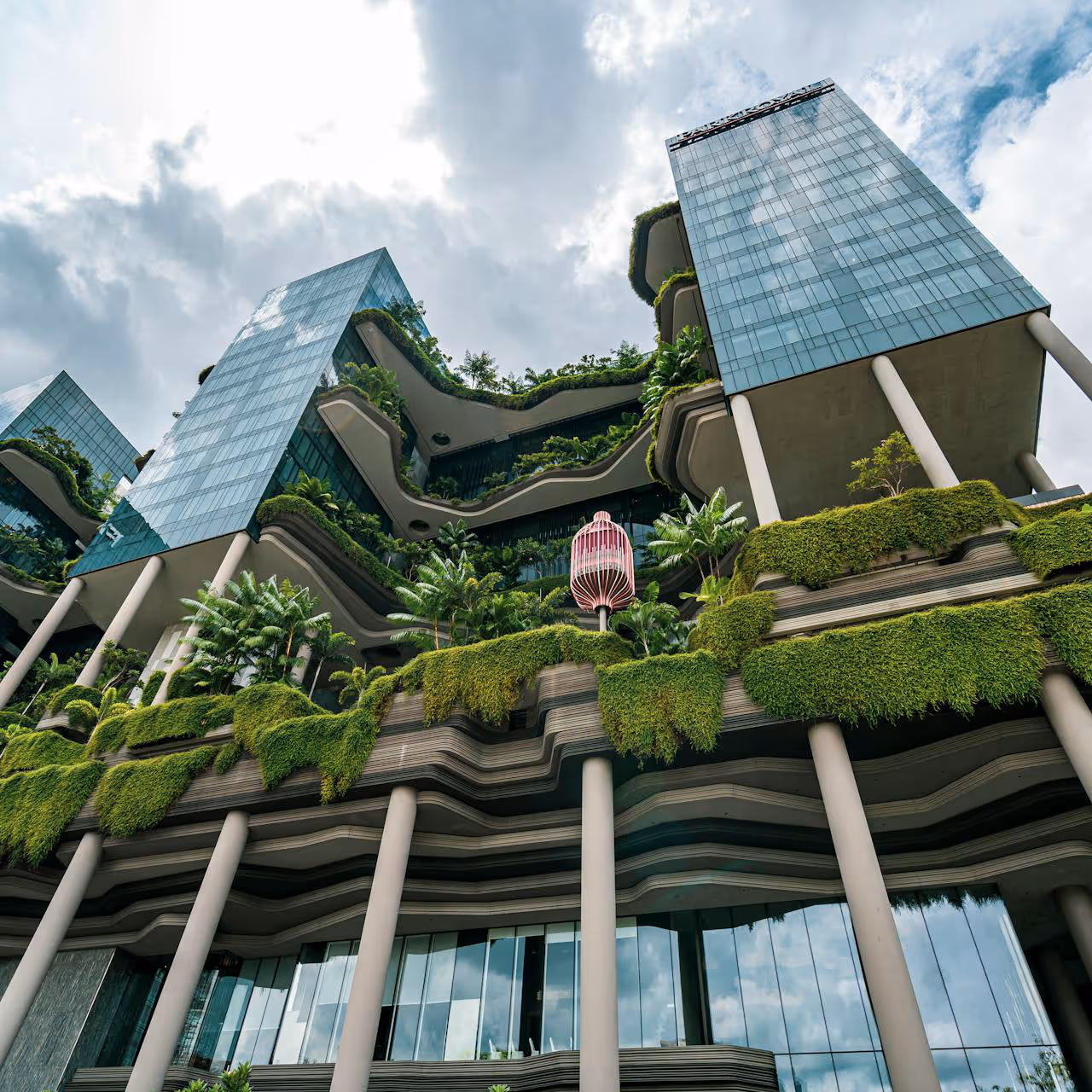 A modern glass skyscraper with biophilic design.