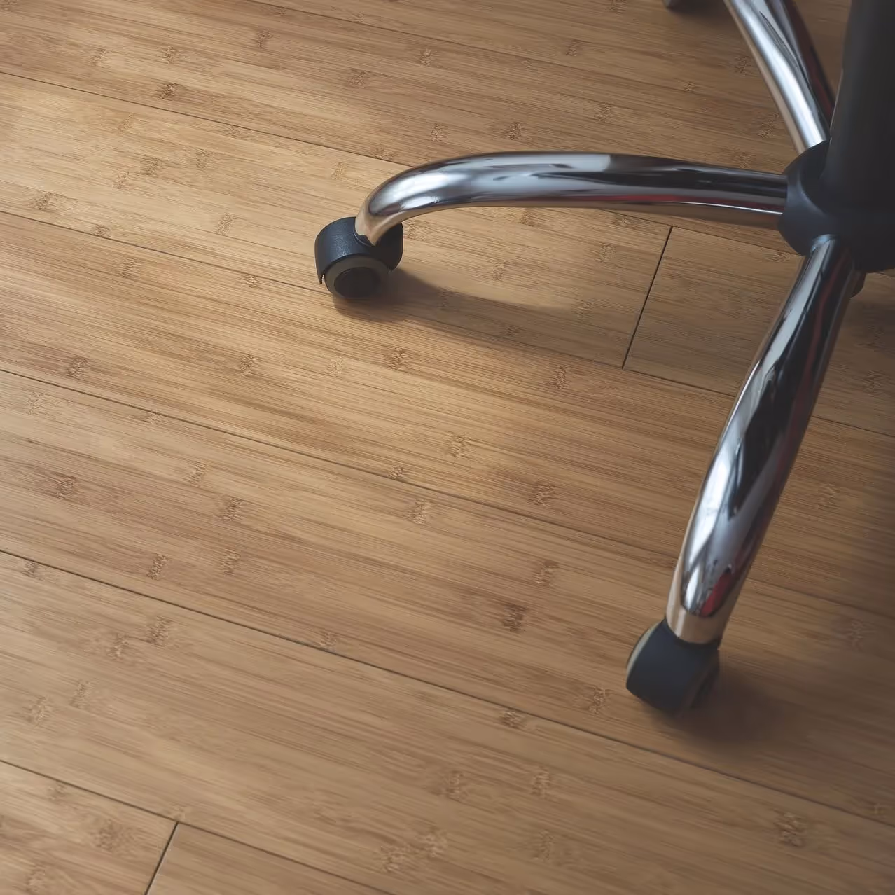 An office chair upon a bamboo floor.