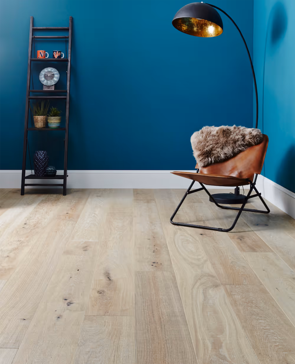 A dark ocean blue painted room with a pale wooden floor.