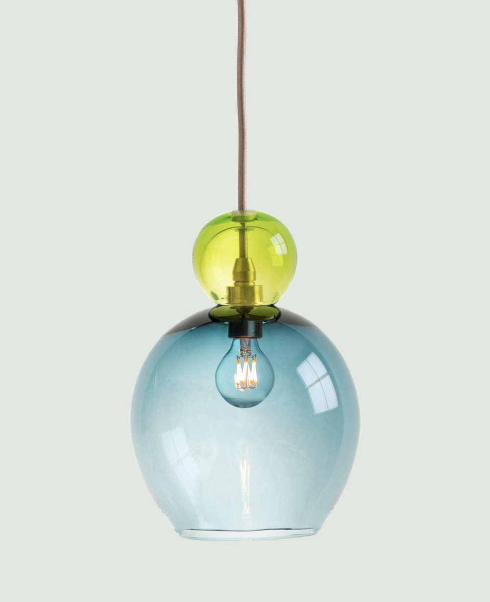 A modern handmade glass pendant light in bright green and muted sea blue.