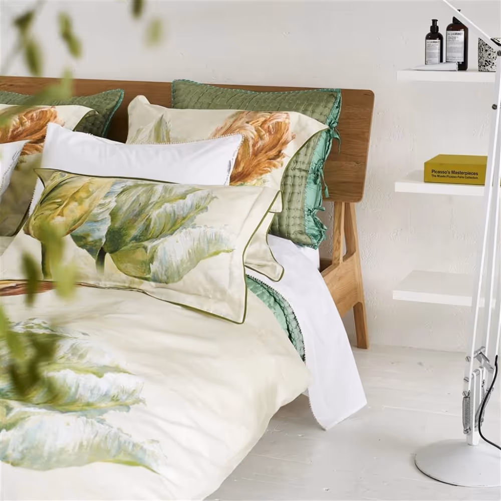 A white bedroom with botanical themed bedlinen in a bold design of giant green tulips.