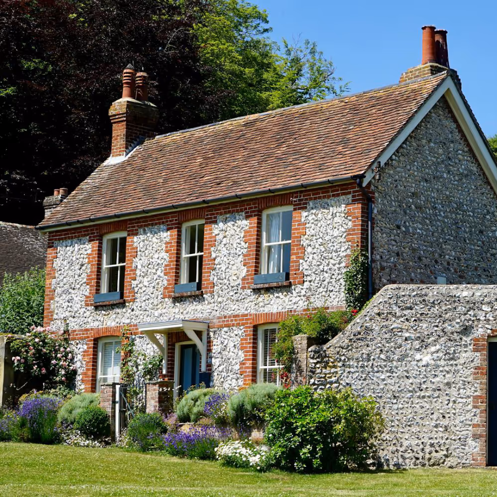 A period stone house with a terracotta tiled roof.