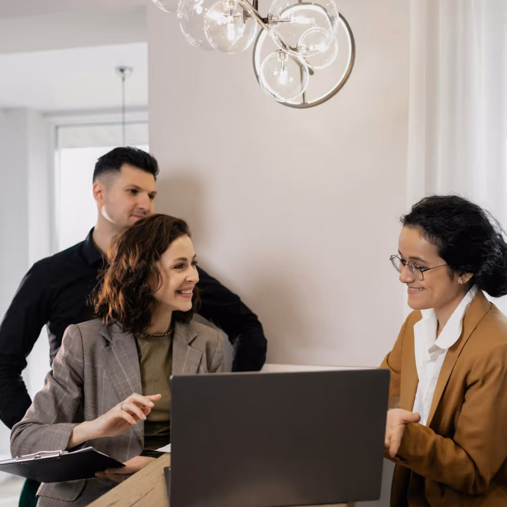A woman in negotiations with a couple on buying a new home.