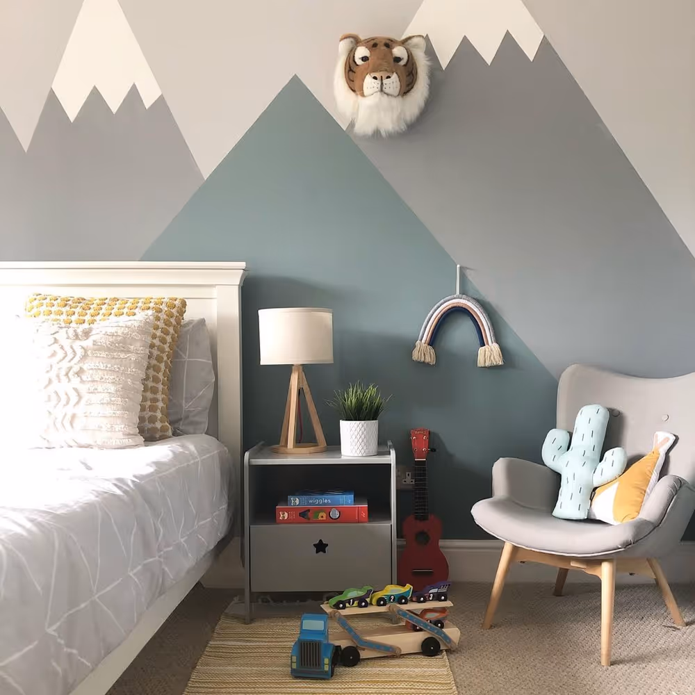 A simplistic mural of snow capped mountains in a child's bedroom